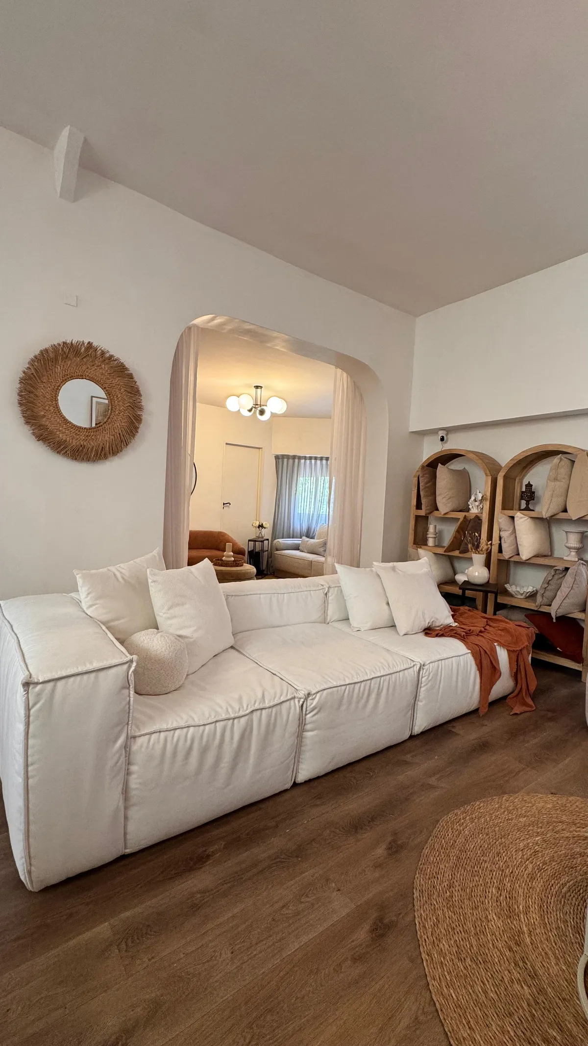 Sofá blanco bajo arco con biblioteca y accesorios decorativos